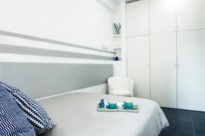a white bedroom with a bed and a chair at Ma Belle Maison in Rome