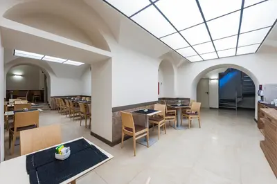 a dining room with tables and chairs in a building at Hotel California in Rome