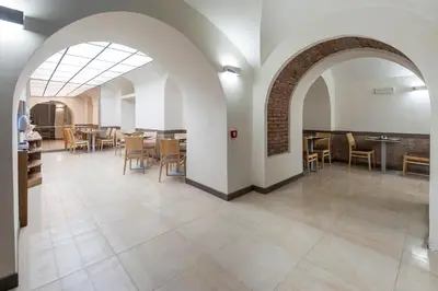 a dining room with an archway and tables and chairs at Hotel California in Rome