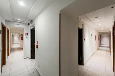 a hallway in a building with white walls and white floors at Hotel California in Rome