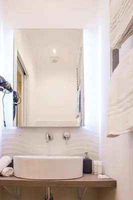 a bathroom with a sink and a mirror at Nazionale Palace Suites in Rome