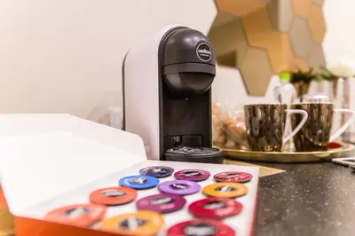 a coffee maker and a box of donuts on a counter at Nazionale Palace Suites in Rome