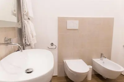 a bathroom with a white sink and a toilet at Nazionale Palace Suites in Rome