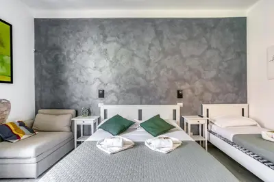 two beds and a couch in a room at Grand Sapienza Apartment by RHR in Rome