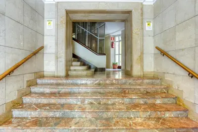 a set of stairs in a building with a stair case at Grand Sapienza Apartment by RHR in Rome