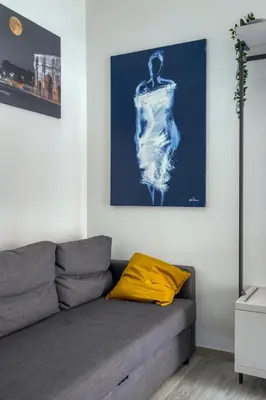 a living room with a couch and a painting on the wall at Grand Sapienza Apartment by RHR in Rome
