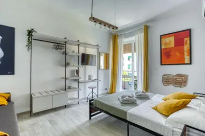 a white bedroom with a bed and a window at Grand Sapienza Apartment by RHR in Rome