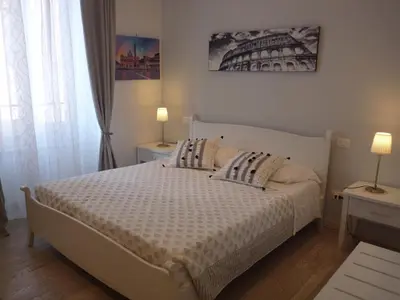 a bedroom with a white bed with two lamps on tables at My Bed Vatican Museum in Rome