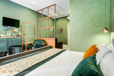 a bedroom with a bed and a green wall at Ripetta Luxurious Suites in Rome