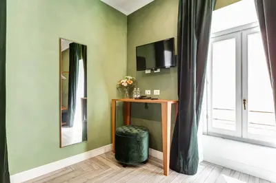 a room with a desk and a mirror and a window at Ripetta Luxurious Suites in Rome