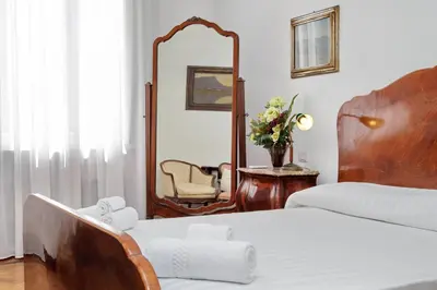 a bedroom with a mirror and a bed and a chair at Prestigious Apartment Via Veneto in Rome