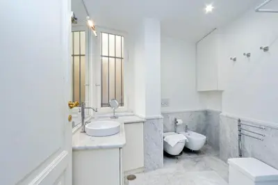 a white bathroom with two toilets and a sink at Prestigious Apartment Via Veneto in Rome