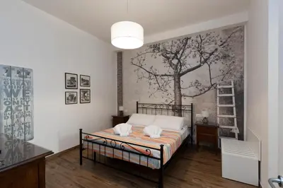 a bedroom with a bed with a tree mural on the wall at Vatican Scipioni 113 in Rome