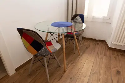 a glass table and three chairs in a room at Vatican Scipioni 113 in Rome