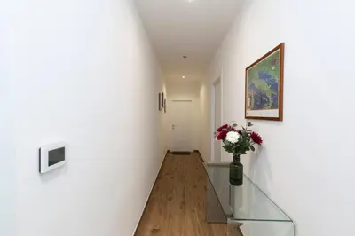 a hallway with a glass staircase with a vase of flowers at Vatican Scipioni 113 in Rome