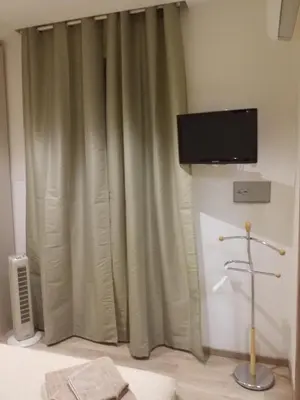 a room with a curtain and a television on a wall at Ponte della musica Teatro Olimpico in Rome