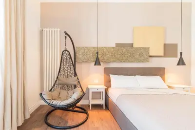 a bedroom with a bed and a swinging chair at Guest Roma House in Rome