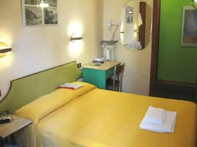 a bedroom with a yellow bed and a desk at A Roma San Pietro Best Bed in Rome
