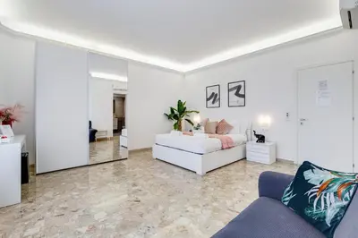 a living room with a white couch and a mirror at DIDAVI' Guest House in Rome