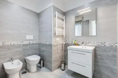a bathroom with a toilet and a sink and a mirror at DIDAVI' Guest House in Rome