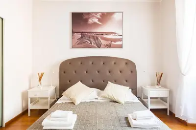 a bedroom with a large bed with two white tables at The Hide Trastevere in Rome