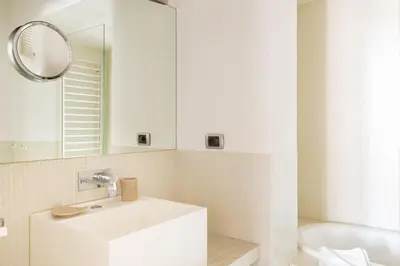 a white bathroom with a sink and a mirror at The Hide Trastevere in Rome