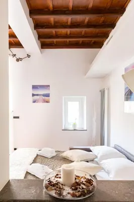 a white room with a bed and a tray with a candle at The Hide Trastevere in Rome