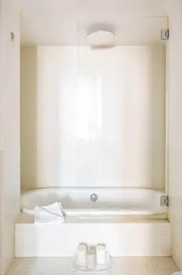a bathroom with a bath tub with a window at The Hide Trastevere in Rome