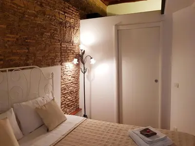 a bedroom with a white bed with a brick wall at The Ancient Wall in Rome