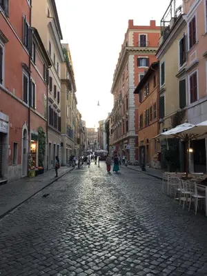 a cobblestone street with people walking down it at The Ancient Wall in Rome