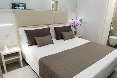a bedroom with a large white bed with pillows at Merulana Holidays in Rome