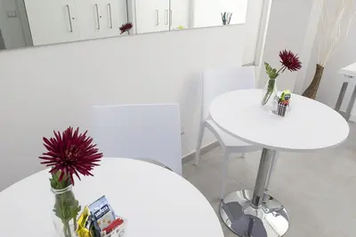 a white table with a vase of flowers on it at Merulana Holidays in Rome