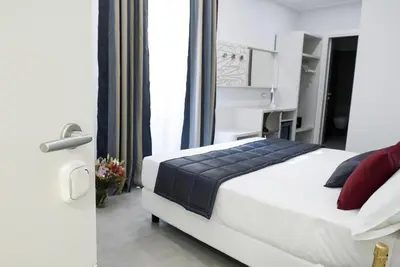 a bedroom with a white bed with red pillows at Merulana Holidays in Rome