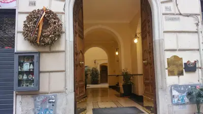 a hallway of a building with a wreath on the wall at Merulana Holidays in Rome
