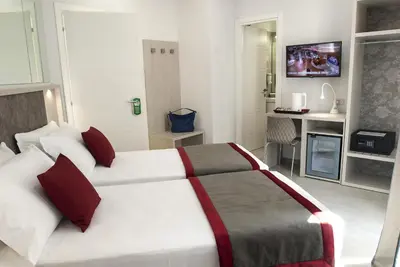a bedroom with a large white bed with red pillows at Merulana Holidays in Rome
