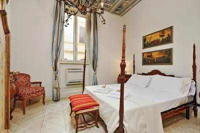 a bedroom with a bed and a chair and a window at Boccaccio 22 in Rome