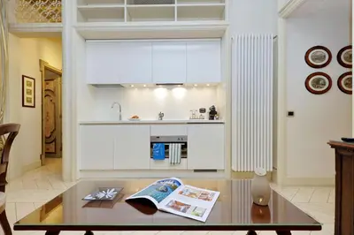 a living room with a table and a kitchen at Boccaccio 22 in Rome