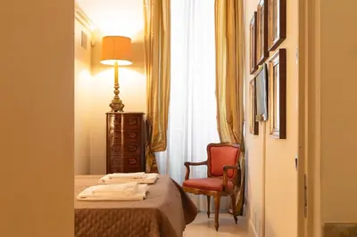a hotel room with a bed and a chair at Boccaccio 22 in Rome