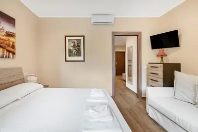 a white bedroom with a bed and a couch at ROMAN DREAM II in Rome