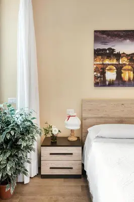 a bedroom with a bed and a lamp on a night stand at ROMAN DREAM II in Rome