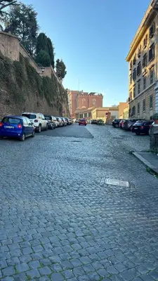 a cobblestone street with cars parked on it at ROMAN DREAM II in Rome