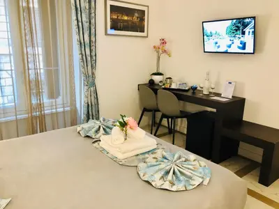 a room with a bed with a desk and a table at KAMBAL LUXURY SUITES in Rome