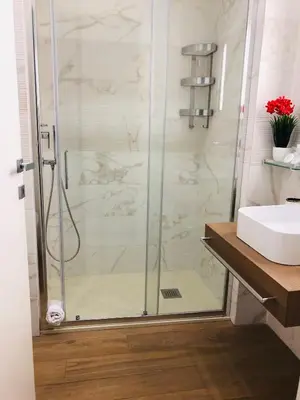 a shower with a glass door next to a sink at KAMBAL LUXURY SUITES in Rome