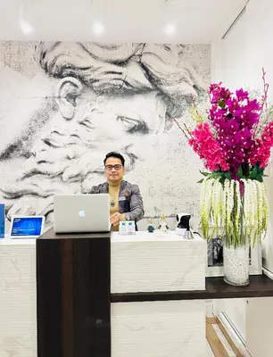 a man sitting at a counter with a laptop at KAMBAL LUXURY SUITES in Rome