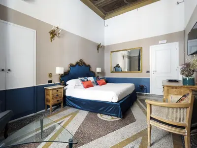a bedroom with a bed and a desk and a mirror at Nobildonne Relais in Rome