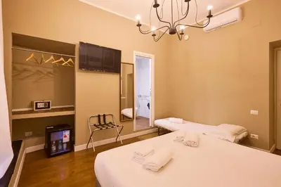 a room with two beds and a television in it at DEM Hotel in Rome