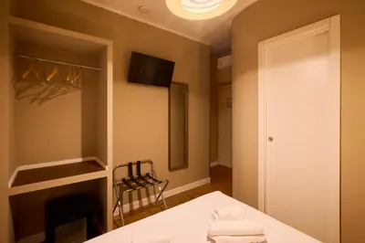 a room with a bed and a fireplace and a television at DEM Hotel in Rome