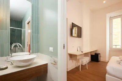 a white bathroom with a sink and a mirror at DEM Hotel in Rome