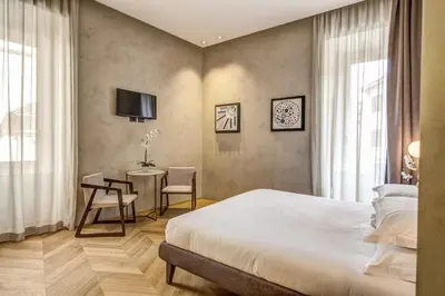 a bedroom with a bed and a table and chairs at G55 Design Hotel in Rome