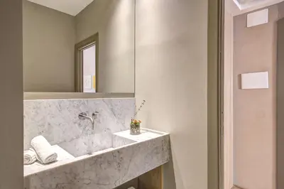a bathroom with a marble sink and a mirror at G55 Design Hotel in Rome